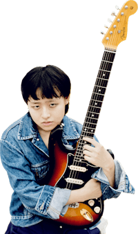 a young man holding a guitar in front of a black background